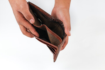 Male hand opening and empty brown leather wallet on white background, bankruptcy and poverty concept.