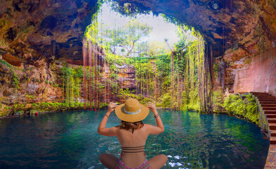 Ik-Kil Cenote sinkhole - Lovely cenote in Yucatan Peninsulla with transparent waters and hanging...
