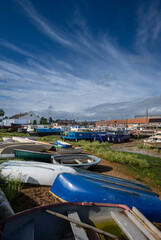 Small boats on a sunny day. View of the quay at low tide on the River Deben in the historic town of Woodbridge in Suffolk, UK.