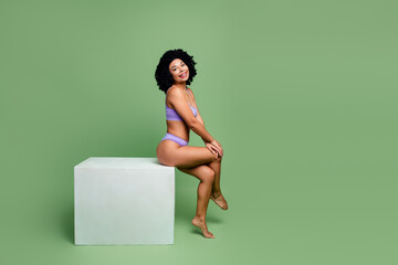 Confident woman in stylish lavender lingerie surrounded by a vibrant green setting enjoying a...