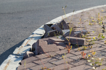 Poorly laid, buckled paving tiles on the city sidewalk