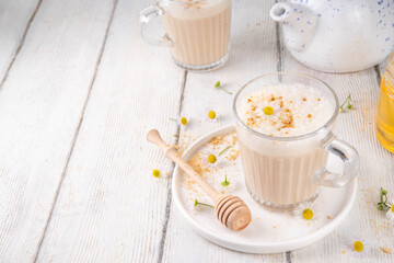 Calming natural chamomile flowers tea latte, organic late night cozy warm beverage with milk and...