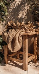 Rustic wooden stool with beige linen and dried leaves