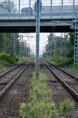 Symmetrical perspective of parallel railway tracks running under a road bridge.