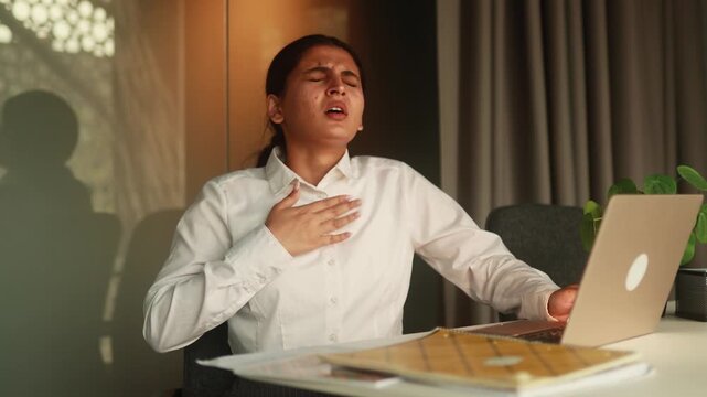 Scary business woman has panic heart attack and trying to calm down at office alone