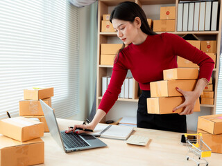 Small business entrepreneurs, SMEs, and independent startups use laptops and boxes to receive and...