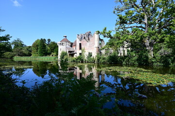 Ruins of a Medieval Moated Manor house by a lake in summertime.