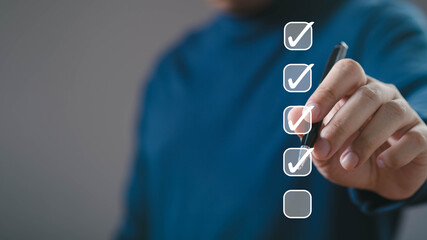 A person checks off tasks on a checklist, indicating productivity and organization.