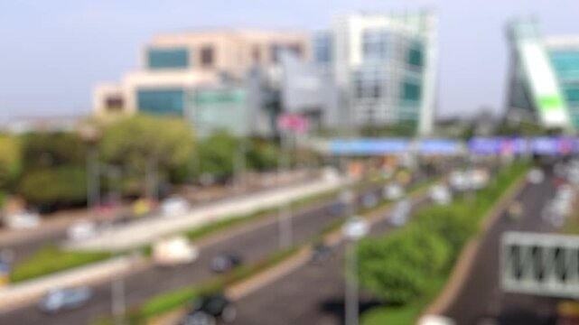 Bokeh view of road traffic and the office buildings of Dlf Cyberhub Cybercity Gurgaon Gurugram, New Delhi, India. Blurred background footage.