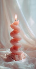 A spiral candle, soft pink hue, on a stone base, bathed in light