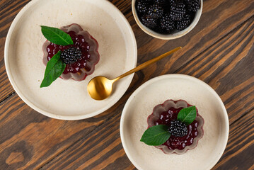 Cherry jelly with fresh blackberry on a brown wooden table. Healthy food, sugar and gelatin free. Top view.