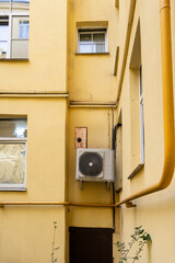 Conditioner. dirty air conditioner unit is mounted on yellow wall. ventilation and cooling of home...