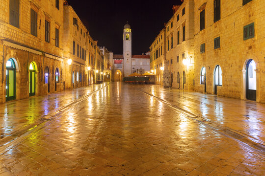 Night view of Stradun Street in Dubrovnik, Croatia, with the illuminated Clock Tower and stone buildings in the Old Town