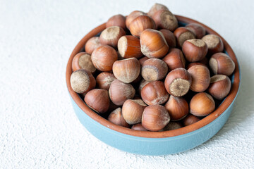 Fototapeta premium Fresh Turkish hazelnuts in shell in bowl in close-up