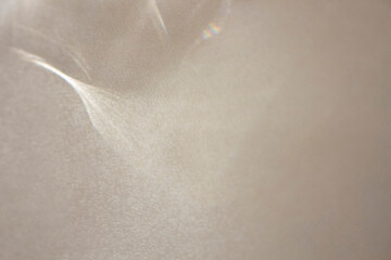 Elegant futuristic minimalistic template with delicate texture,blurred plastic glowing reflective shapes,shimmers and bokeh elements.Trendy layering style concept on beige-gray background for design.