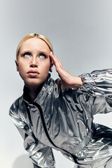 Young blonde woman showcases futuristic fashion in an artistic studio setting