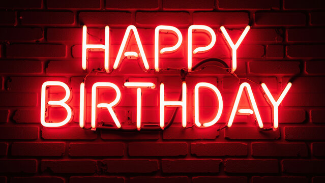 Happy birthday neon sign glowing brightly against brick wall, creating festive atmosphere for celebrations