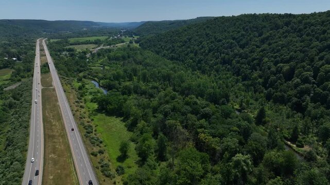 Driving on American highway past green rolling hills and peaceful landscape near Wallace, NY