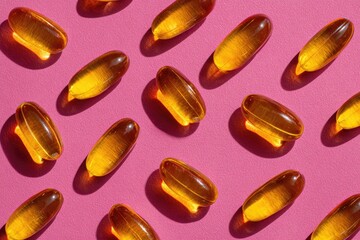 Golden capsules on pink background