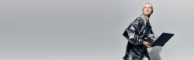 Futuristic blonde woman in sleek outfit embraces technology in a modern studio