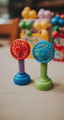 Two small, colorful plastic toy fans