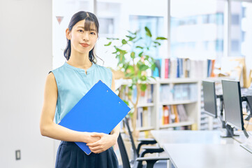 オフィスでファイルを持つ若い女性　ビジネスシーン