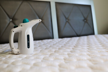 A steamer sitting on top of a mattress to kill bedbug 