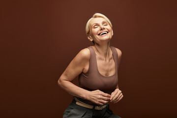 Joyful senior woman expressing happiness in a warm toned setting with elegant charm