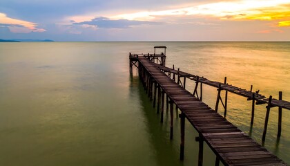 Fototapeta premium Wooden Pier Extending into Ocean at Sunset