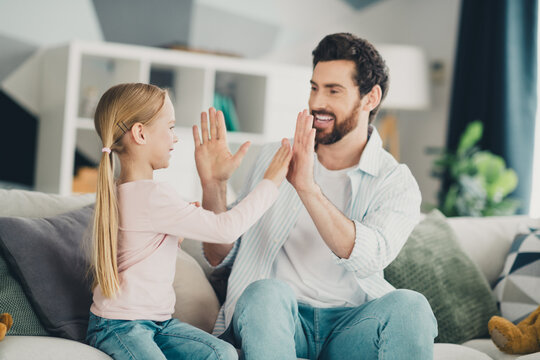 Father and daughter enjoying quality time together playing a clapping game in a cozy and modern home setting
