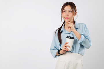 Young thoughtful woman holding coffee cup takeaway, thinking with a paper cup in hand, she...