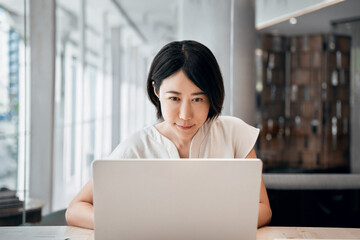 Young asian entrepreneur manager businesswoman using pc for communication, learning at workplace. Focused mature eastern business woman working on laptop computer sitting at office workplace desk