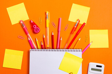 School Supplies with Sticky Notes on Orange Background