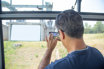 Man taking picture in nature by smartphone.