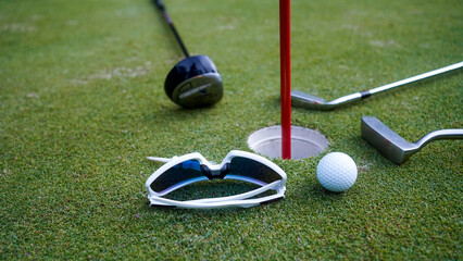Close up of golf equipment on green grass.