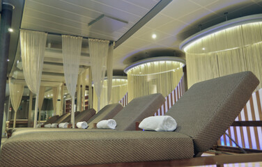 Softly padded loungers inside relaxation tea room in thermal suite wellness area onboard luxury...