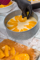 Peach cheesecake. Pastry chef decorates the cheesecake with sliced fruit