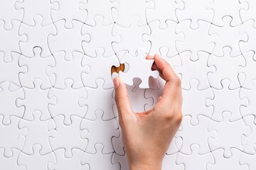 Completing the puzzle concept hand placing last piece of jigsaw puzzle solution done