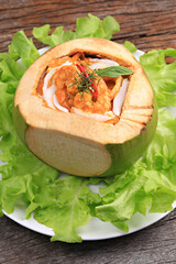 Steamed Curry Seafood in Coconut on old wooden backdrop, Thailand's most popular seafood dishes