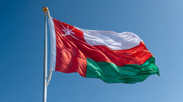 Oman flag waving brightly against a clear blue sky on Independence Day celebration