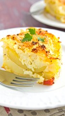 Close-up of a slice of potato and cheese casserole.