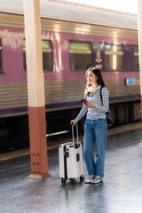 Young Asian woman traveler with luggage at train station with travel concept, woman walking at train station