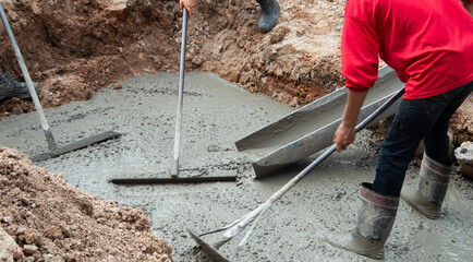 Workers are helping to level the concrete floor.