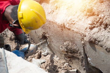 Workers are using a concrete hammer drill.
