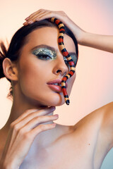 Young beautiful woman confidently posing with a striking snake in a captivating artistic display