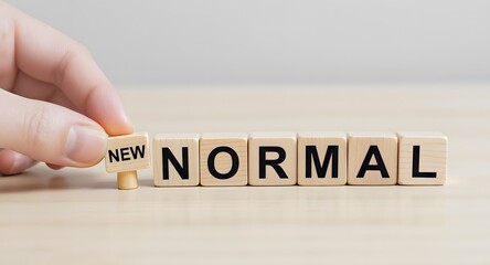 Man's hand with concept of new normal, wooden block cubes for new normal wording The world is changing to balance it into new normal include business , economy , environment and health.