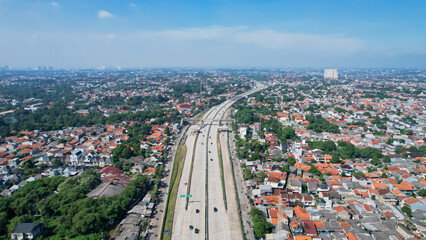 Aerial View of a Desari (Depok-Antasari) Toll Road and residential areas with clear blue sky in the...