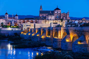 Roman Bridge and Mosque Cathedral of Córdoba illuminated at dusk.
