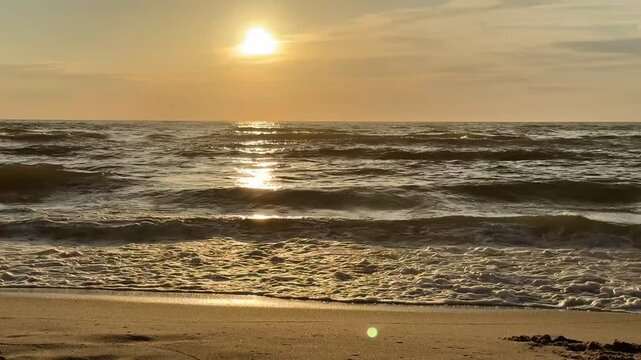 Romantyczny zach&oacute;d słońca nad morzem, złoty zach&oacute;d, morska plaża, chmury, szum fal, wzburzone morze. 4k.