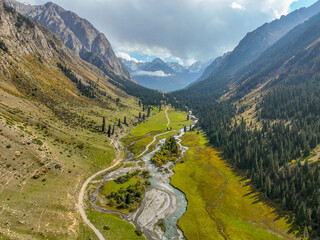 An epic aerial perspective of the picturesque Barskoon valley, showcasing a braided river flowing...